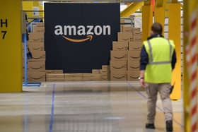 A US giant Amazon employee passes by its logo on the opening day of the new distribution center in Augny, eastern France, on September 23, 2021. (Photo by SEBASTIEN BOZON/AFP via Getty Images)