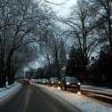 Cars drive on snowy roads.