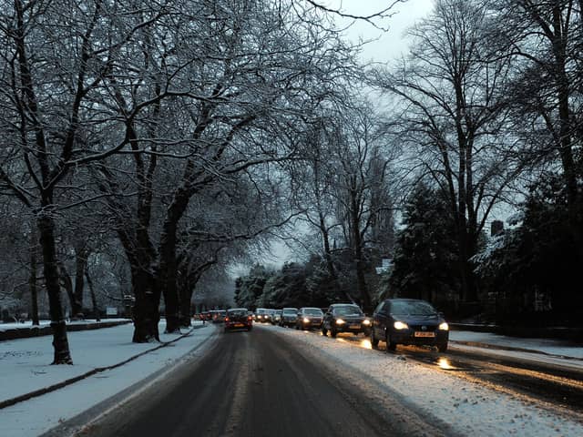 Cars drive on snowy roads.