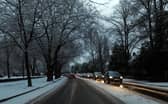 Cars drive on snowy roads.