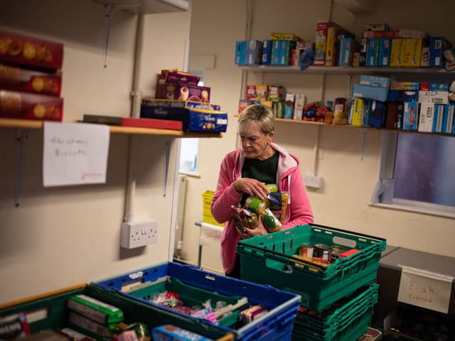 A worker at the Coventry Foodbank centre in Queens Road Baptist Church collates donated food items into parcels that will be provided to people arriving with a foodbank voucher.
