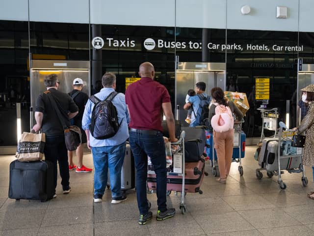 People queue for a lift at Heathrow Airport.