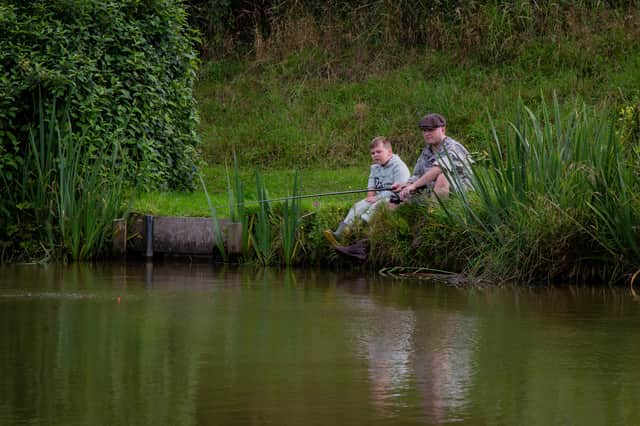 Alexander Sparkes, 7, fishing with his new Hero Arm with Dad Robin Sparkes, 31, at Cornfield Fisheries in Burnley