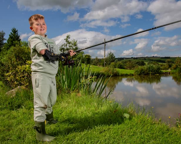 Alexander Sparkes, 7, fishing with his new Hero Arm with Dad Robin Sparkes, 31, at Cornfield Fisheries in Burnley