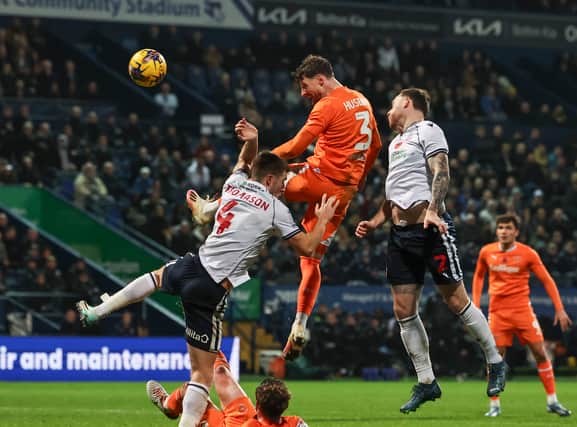 Blackpool's James Husband heads for goal under pressure from Bolton Wanderers' George Thomason and Gethin Jones