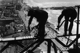 15th August 1934: Balancing on girders high above the promenade workmen repair Blackpool Tower
