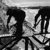 15th August 1934: Balancing on girders high above the promenade workmen repair Blackpool Tower