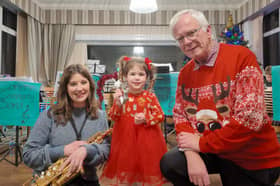 Little Scarlett Hughes, 3, jingles some bells with the Carleton Community Band
