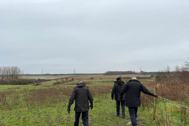 Police officers searching the rural land behind The Harbour