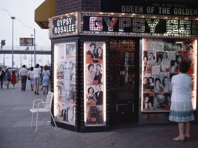 A woman ponders the illuminated front of Gipsy Rosalee's fortune telling service i9n 1983. The sign says that Gipsy Rosalee was the queen of the Golden Mile and the photographs display famous customers including Jimmy Tarbuck and Eddie Large 