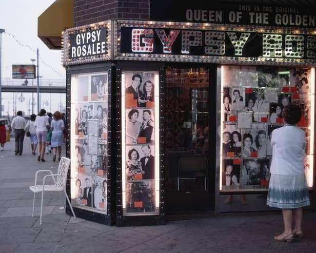A woman ponders the illuminated front of Gipsy Rosalee's fortune telling service i9n 1983. The sign says that Gipsy Rosalee was the queen of the Golden Mile and the photographs display famous customers including Jimmy Tarbuck and Eddie Large 