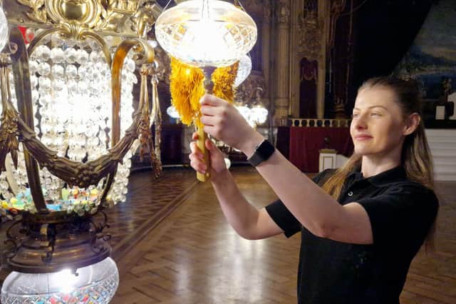 A member of staff dusts the chandeliers in Blackpool Tower Ballroom