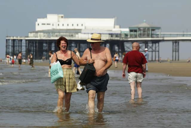 A couple walk on the sea on Blackpool beach.