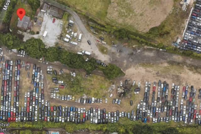 The property (red arrow) has multiple cars dumped, or illegally parked around it.