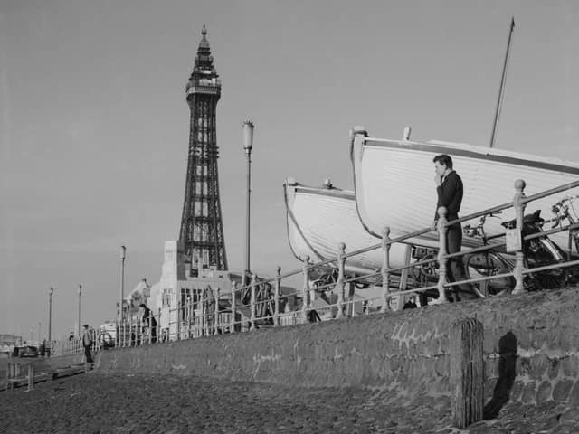 A man looks out over the beach in front of Blackpool Tower next to two large boats supported on carriages, 1950 (Photo by The Montifraulo Collection/Getty Images)