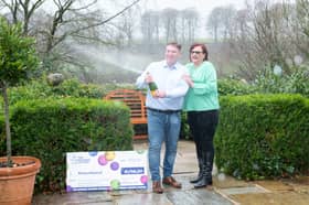 Richard and Debbie celebrating their EuroMillions win with champagne.