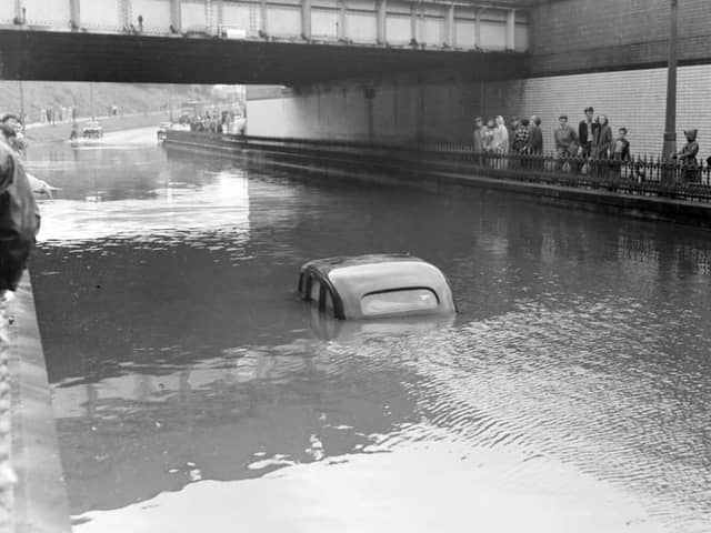 A terrific thunderstorm and downpour of rain caused flooding in several areas of Blackpool in 1958. The depth of the water under the railway bridge at Devonshire Road is indicated by the stranded car