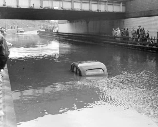 A terrific thunderstorm and downpour of rain caused flooding in several areas of Blackpool in 1958. The depth of the water under the railway bridge at Devonshire Road is indicated by the stranded car