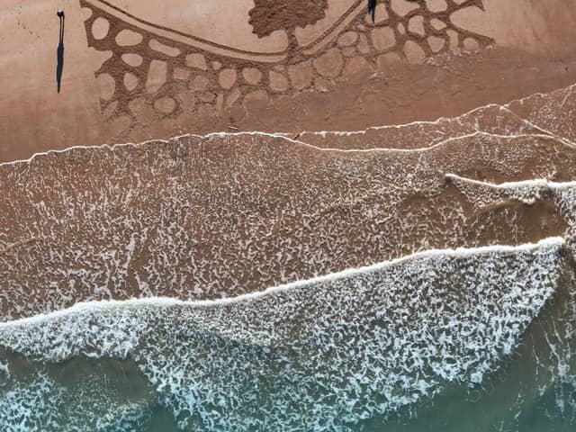 Volunteers carved a giant 100ft tribute to the Sycamore Gap Tree as it reaches six months since the iconic tree was chopped down by vandals. 