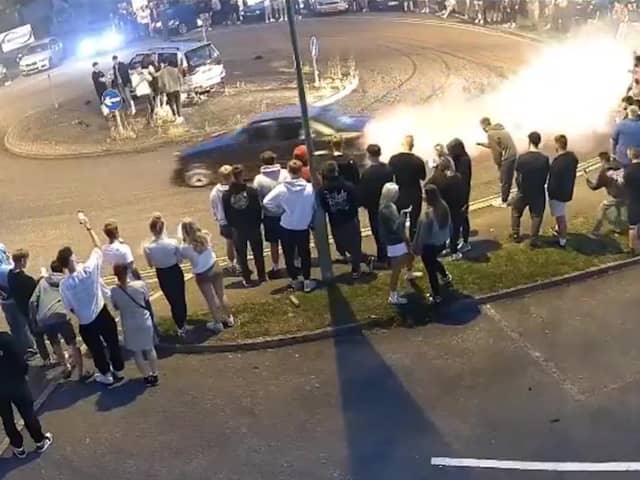 Driver does doughnuts at illegal car meet.