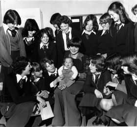 Mrs Vivien Saunders keeps a firm hold on her four month old son Guy Saunders who is surrounded by his adopted "mums" - the girls of the home and child care class at St George's High School, Marton