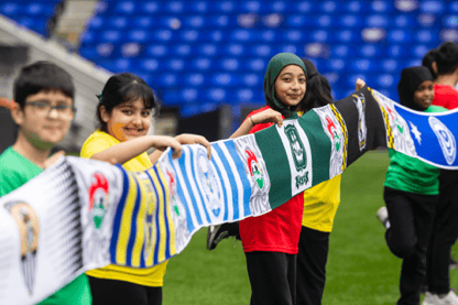 Kellogg's multi-club football scarf being held by children from local schools.