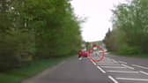 Deer runs across busy main road causing car to swerve.