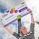 Lottery winner Raymond Young celebrates his win in front of Blackpool Tower. (Credit: Anthony Devlin)