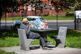 A man sits at the chess board with his shopping.