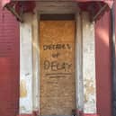 Decades of decay daubed across a door in Foxhall