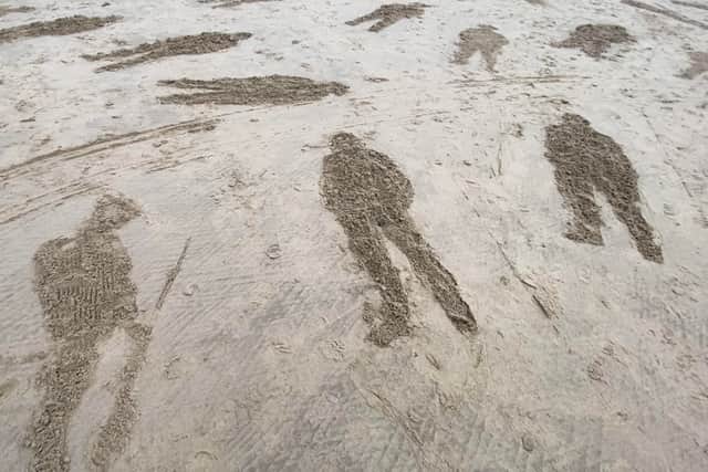 Participants created powerful sand art using stencils to portray life-sized soldiers on the beach