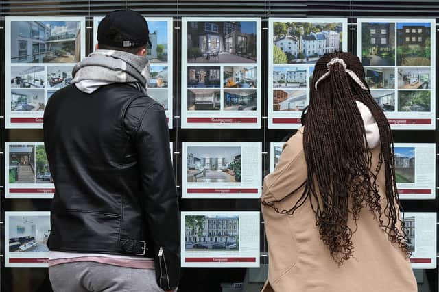 People look at residential properties displayed for sale in the window of an estate agents' in London (Photo: ISABEL INFANTES/AFP via Getty Images)