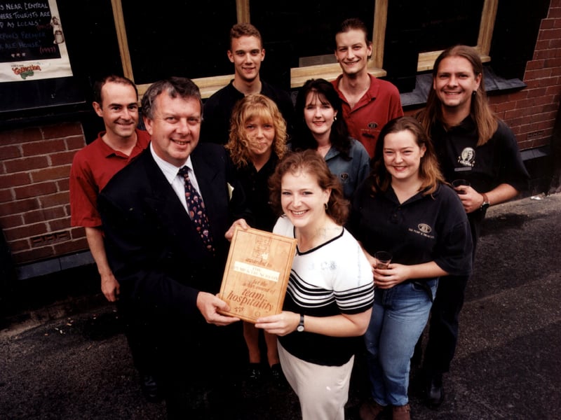 Whitbread Bowland Inns' managing director, Norman Jepson (front left) is seen presenting licensee Pauline Tiernan and her team of staff with a Hospitality award at the Pump and Truncheon