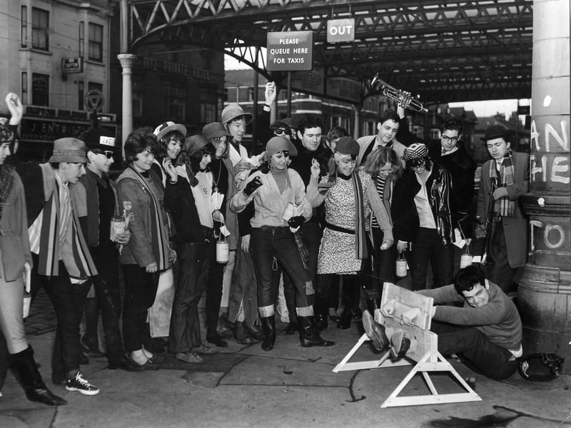 A student waits for 'punishment' in the stocks at North Station as part of a Rag Day fundraising stunt for Blackpool Technical College and School of Art students in 1964