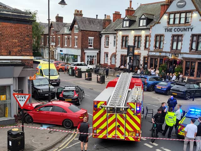 A red Mercedes crashed into the Queens Chicken and Pizza Shop in Lytham. Police and firefighters at the scene