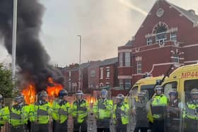 A police van set alight as trouble flares during a protest in Southport