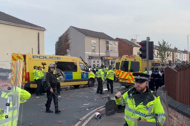 Officers put on helmets and riot gear after stones and bottles were launched at them and police vehicles were damaged and set on fire. Credit: PA
