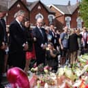 Prime Minister Sir Keir Starmer observes the floral tributes near the scene in Hart Street, Southport