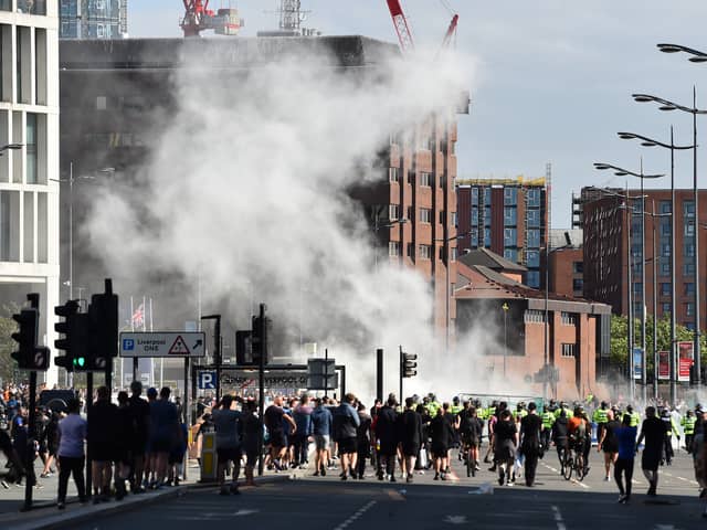 Smoke billows as police officers face off protesters in Liverpool on August 3, 2024 during the 'Enough is Enough' demonstration held in reaction to the fatal stabbings in Southport on July 29.