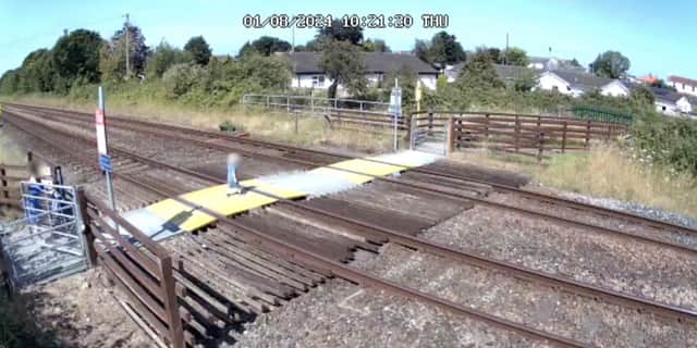 Toddler steps onto Sandy Lane level crossing in Prestatyn, North Wales.