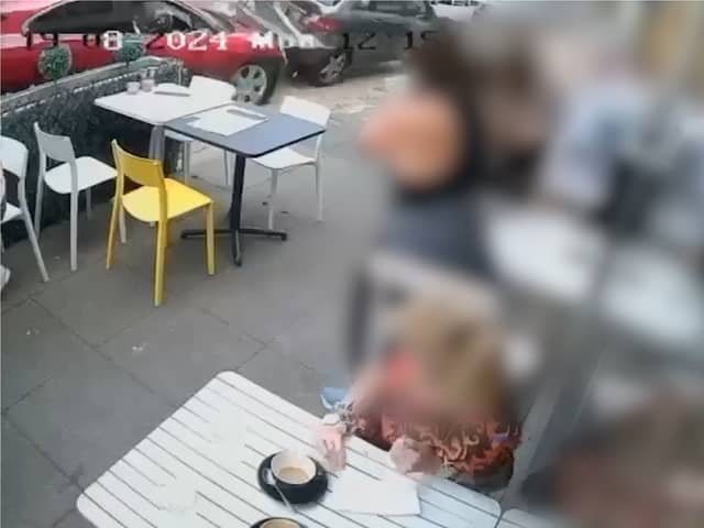 Two cars crash onto pavement narrowly missing café customers.