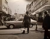 Littlewoods, Timpsons and a sign for Alexandra Clothing are pictured in this photo. The police officer looks like he was moving traffic cones. At the time road works were going on in Church Street