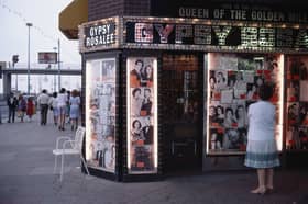 A woman ponders the illuminated front of Gipsy Rosalee's fortune telling service i9n 1983. The sign says that Gipsy Rosalee was the queen of the Golden Mile and the photographs display famous customers including Jimmy Tarbuck and Eddie Large