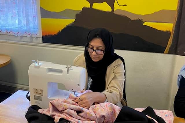 Afghan refugee Aziza at her sewing machine
