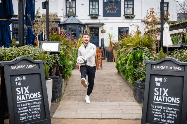 Former England rugby international Danny Care kicking a ball "into space" from outside the Greene King sport pub The Barmy Arms in Twickenham
