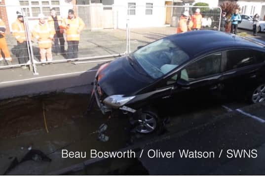 A car being towed out of a sinkhole