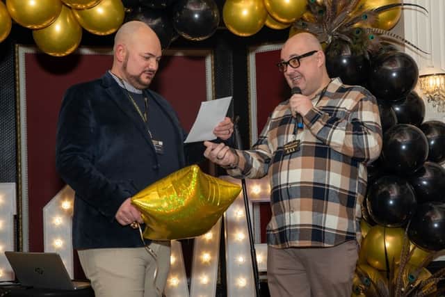 Liam Halewood (left) is given the appointment notice of his hair transplant by fiance Michael Hopkins. Photo: Steve Lowery Photography