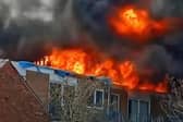 Pictures from a blaze at a block of flats in South Shore show the fire tearing through the roof.