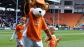 Bloomfield Bear has a kickabout with youngsters ahead of the Blackpool FC V Bolton Wanderers match.