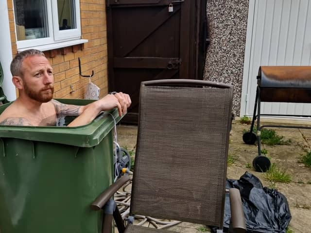 Martin Lynch taking a cold water bath in his wheelie bin